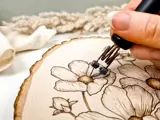 flower design being burned into end of log cut off