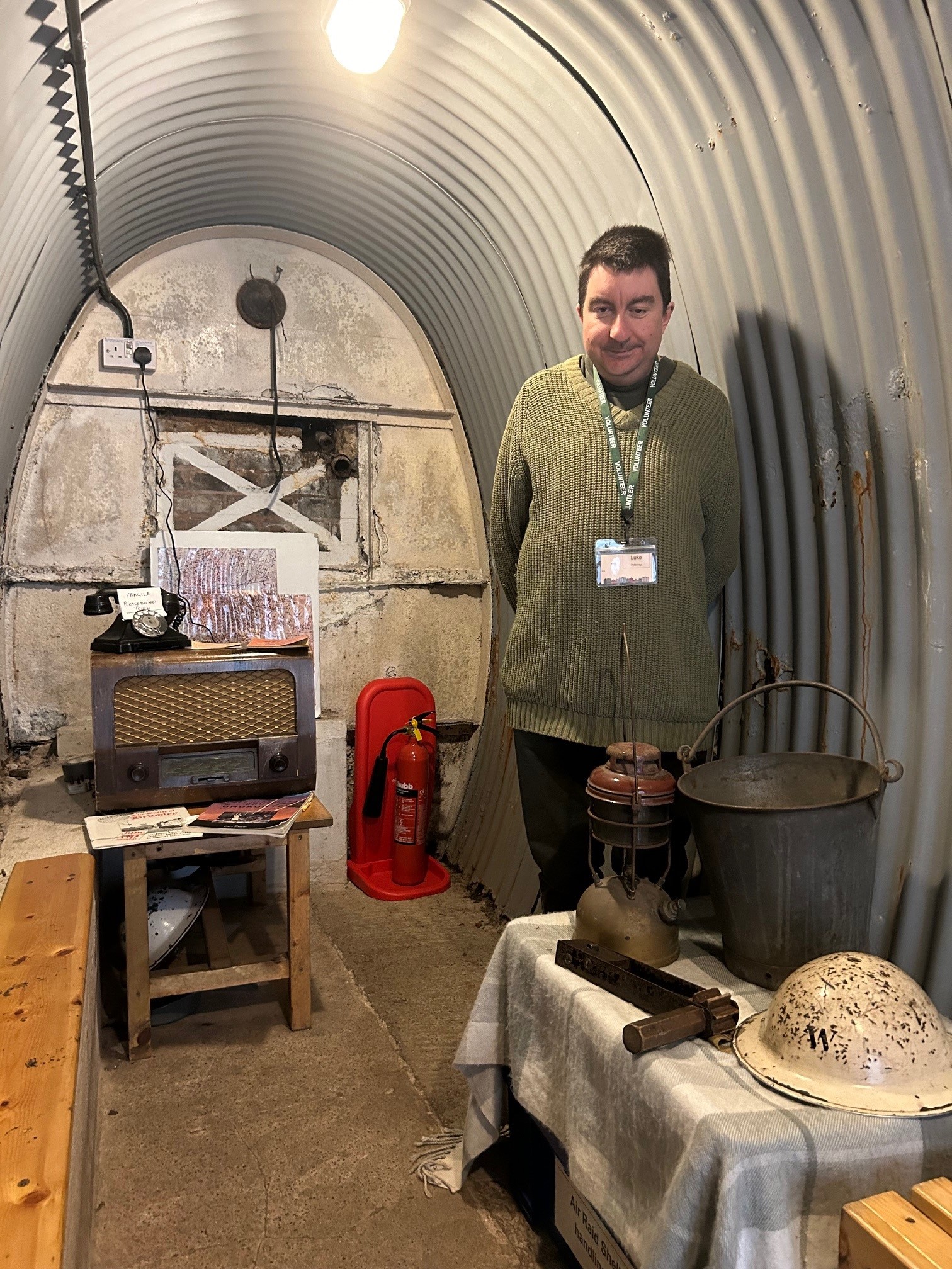 man with lanyard stood in air raid shelter