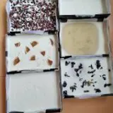 six handmade soaps on a table some with petals in