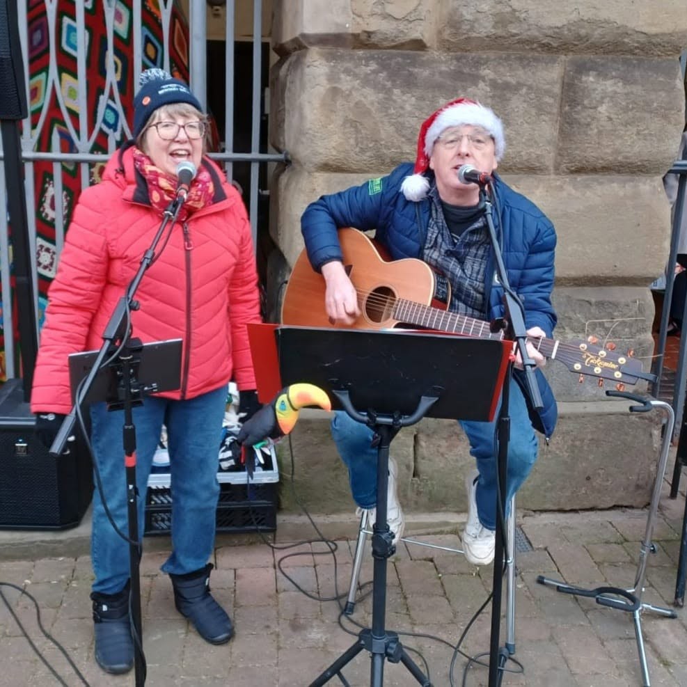 singing duo outside museum entrance at Christmas time