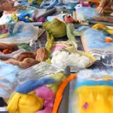 various colours of felt being used fir wet felting workshop place on a table
