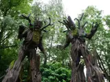 two trees looking like they have craved faces and look scary - there are tree giants