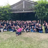 large group of people gathered together in outdoor theatre singing