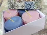 assortment of coloured candle tealights in small glass containers within in a pretty gift box