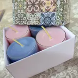 assortment of coloured candle tealights in small glass containers within in a pretty gift box